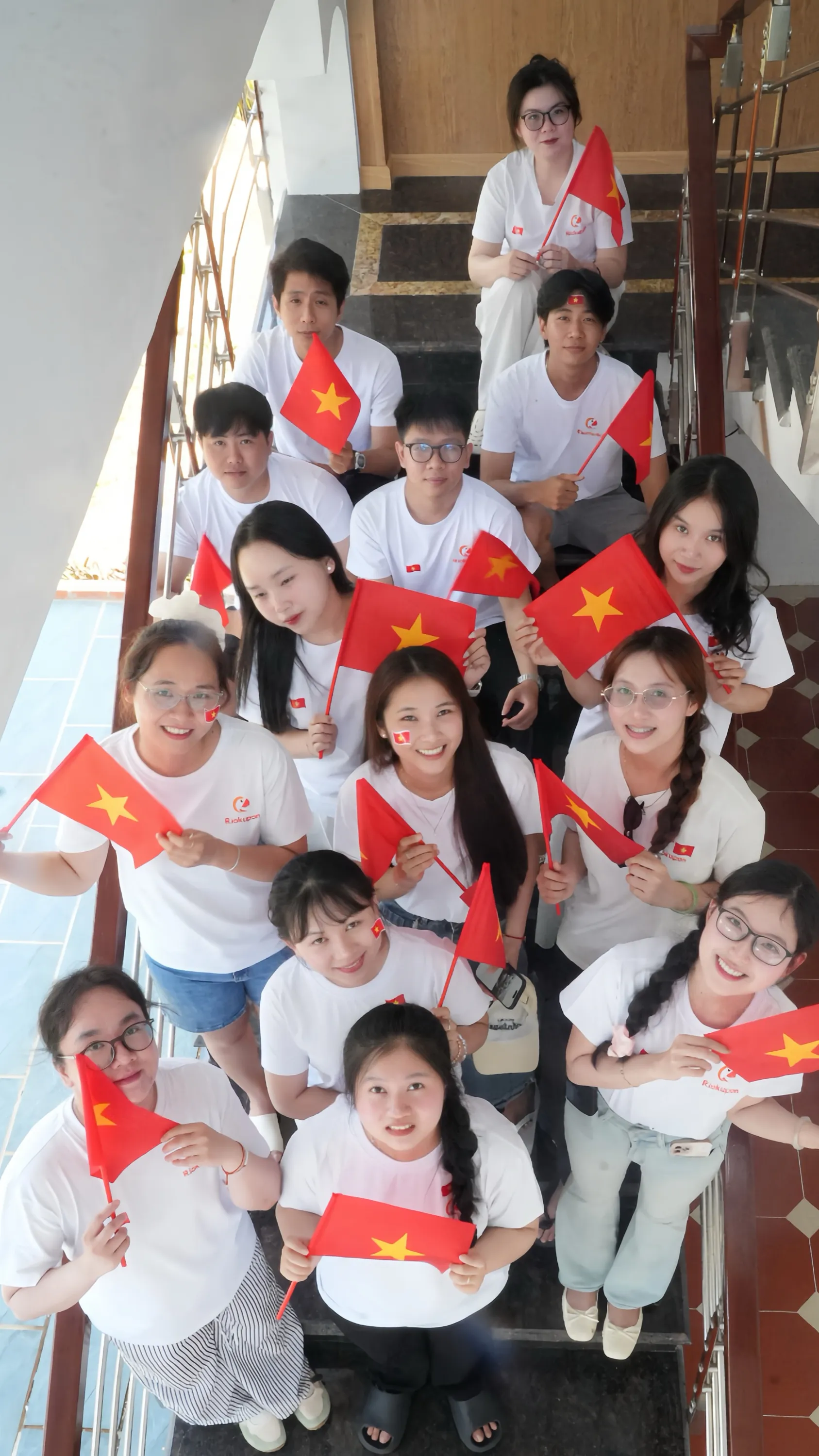 Thành viên DIMACO cầm cờ đỏ sao vàng tại văn phòng